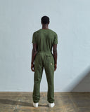 Full-length reverse view of model wearing Uskees  #7009 coriander-green organic cotton joggers paired with matching Uskees t-shirt.
