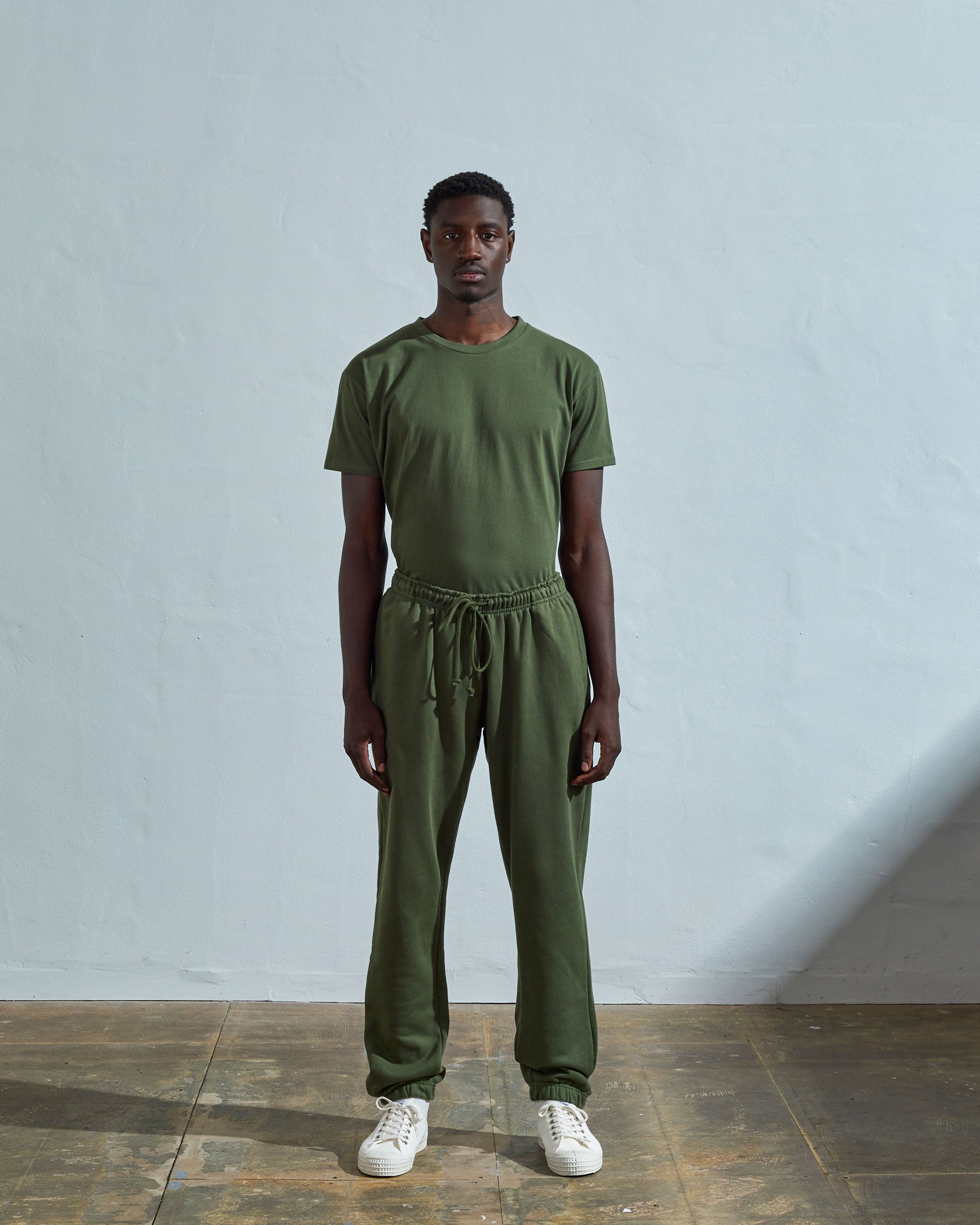 Full-length front view of model wearing #7009 coriander-coloured medium weight basic jogging pants from Uskees.