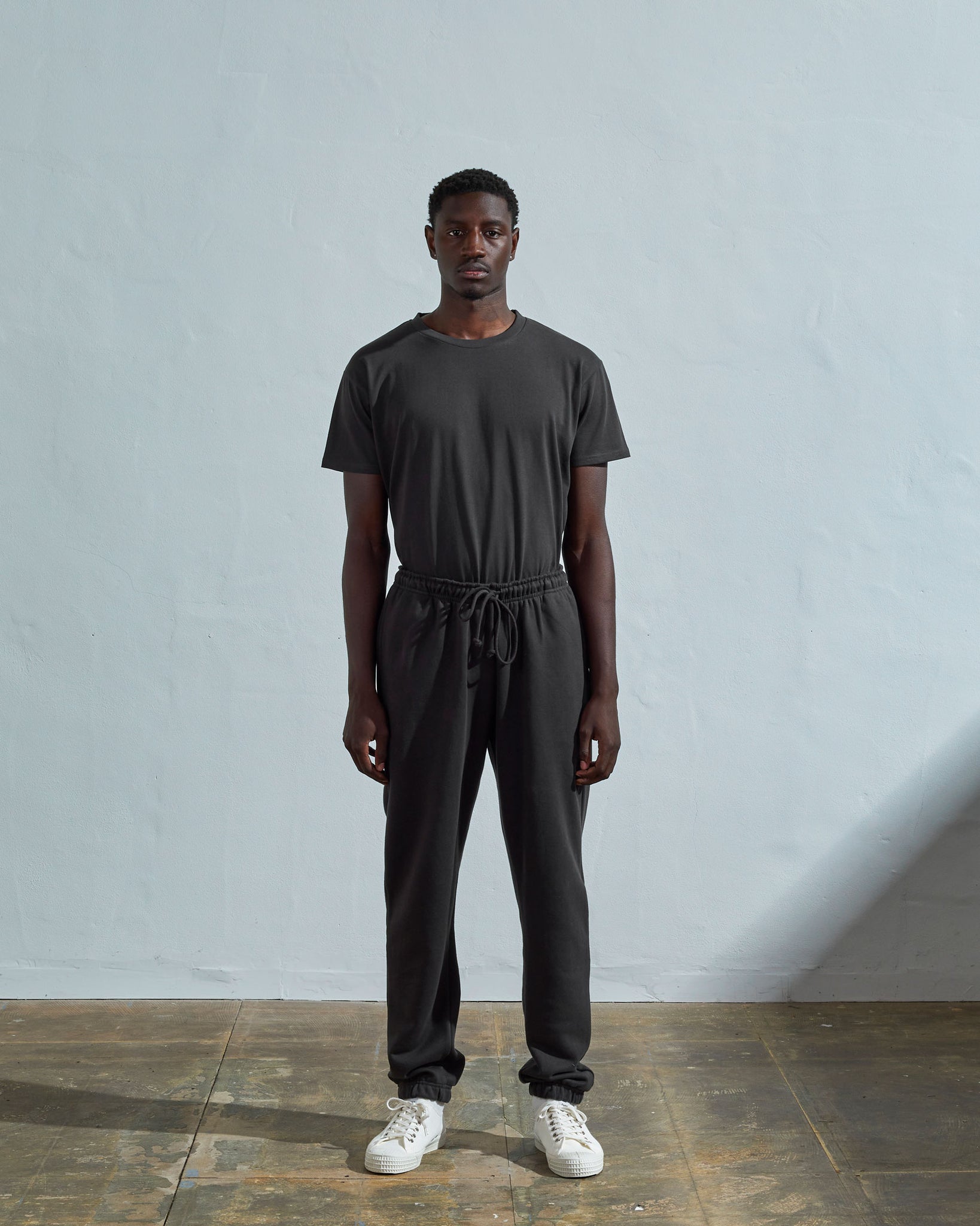 Full-length front view of model wearing #7009 faded black medium weight basic jogging pants from Uskees.