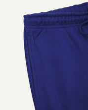 Close up view of organic cotton joggers in ultra-blue showing the side pocket and drawstring waist.