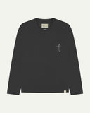 Full flat view of faded black organic cotton Uskees long-sleeve T-shirt for men, showing the small white 'Jazz Man' logo on the breast pocket and the Uskees branding labels on the neck and hem.