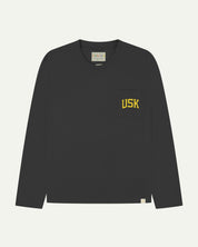 Full flat view of faded black organic cotton signature long sleeve T-shirt for men, showing the varsity inspired 'USK' logo in yellow on the chest pocket, and the Uskees branding labels on the neck and hem.