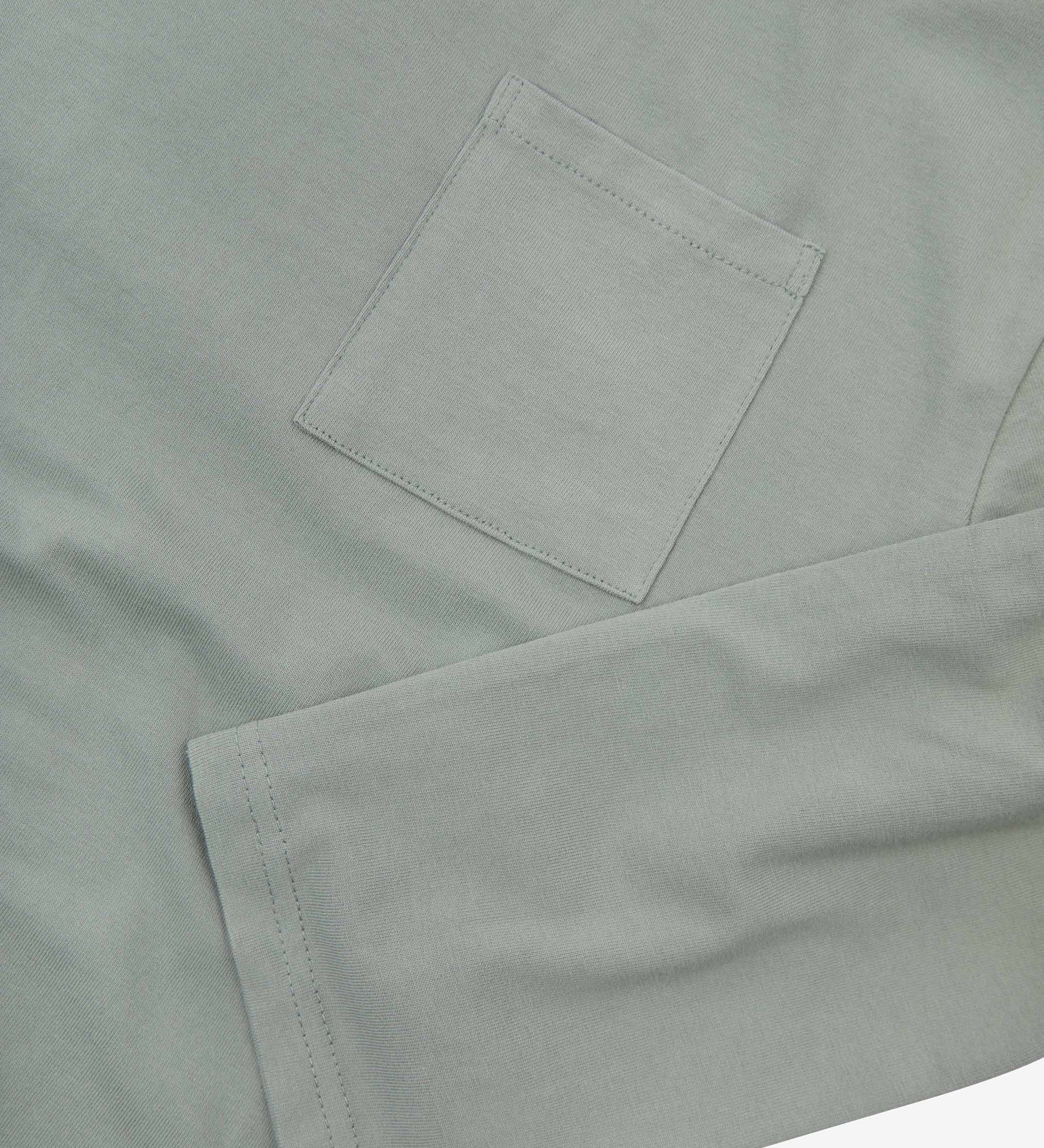 Closer look at the chest pocket and cuff of the grey-green 'steel' coloured organic cotton long sleeve T-shirt showing texture of the medium weight organic cotton jersey.