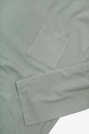 Closer look at the chest pocket and cuff of the grey-green 'steel' coloured organic cotton long sleeve T-shirt showing texture of the medium weight organic cotton jersey.