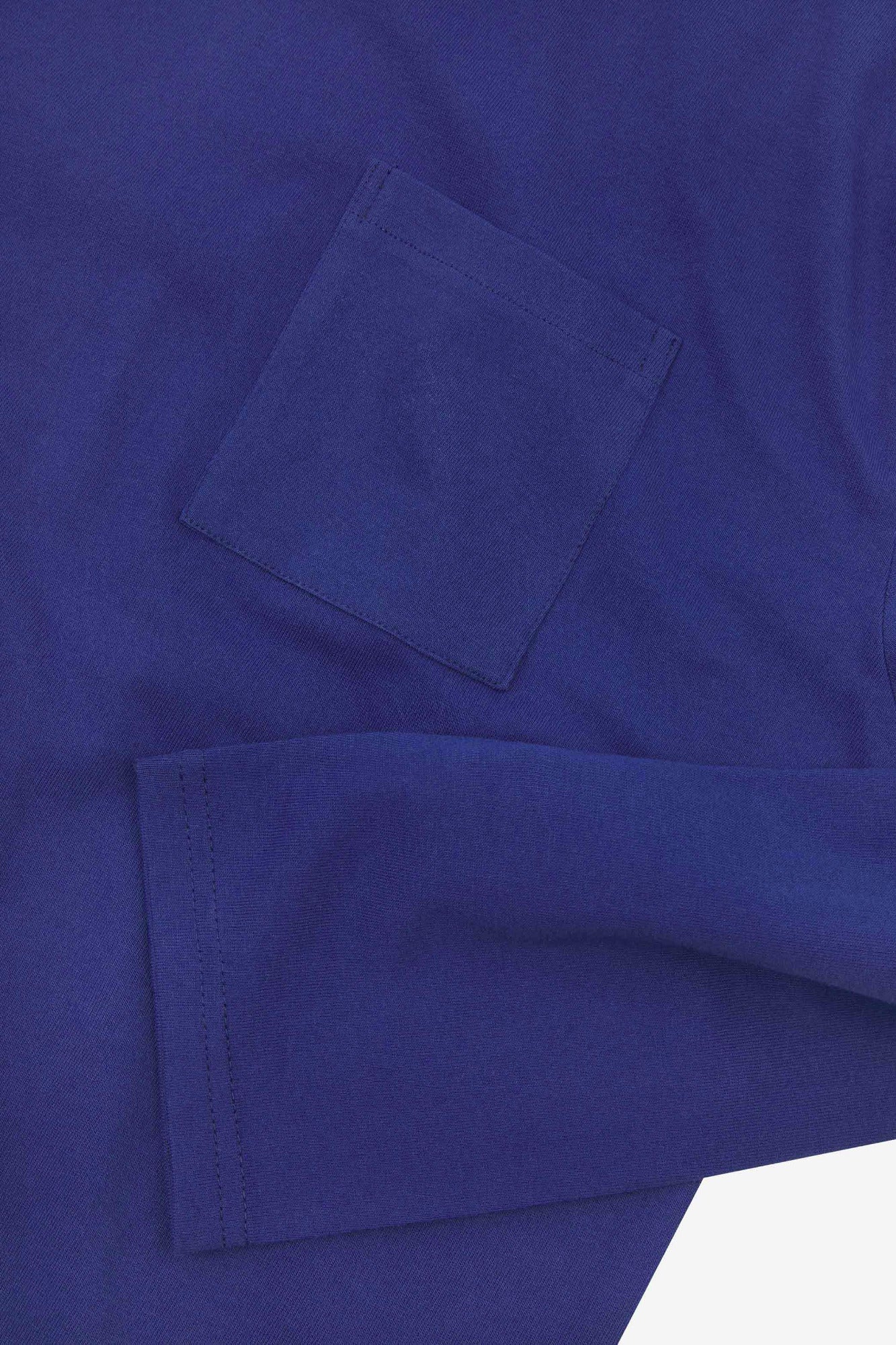 Closer look at the chest pocket and cuff of the ultra blue organic cotton long sleeve T-shirt showing texture of the medium weight organic cotton jersey.