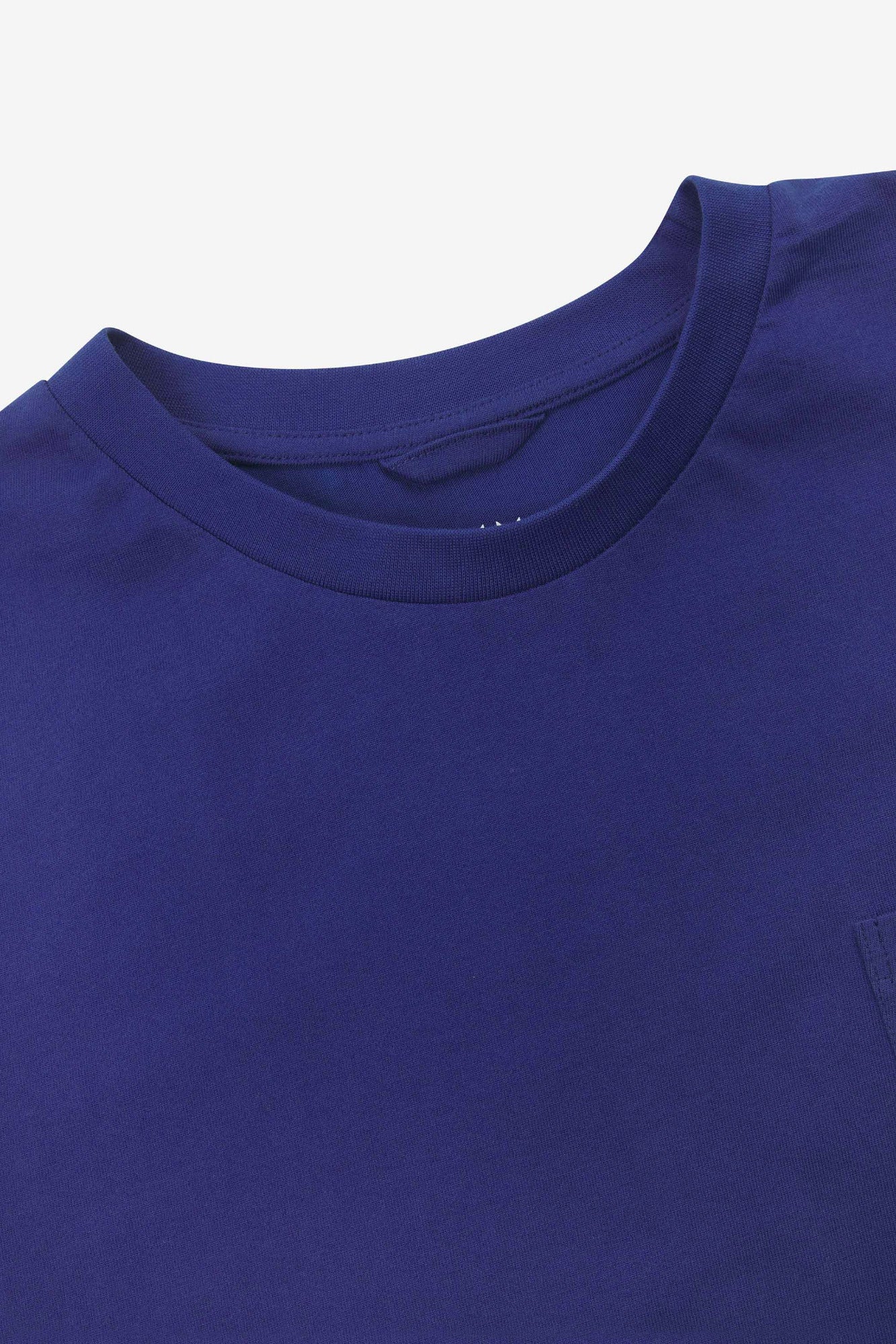 Neckline close-up of Uskees ultra blue organic cotton long-sleeve T-shirt showing hanging loop and branding stamp.