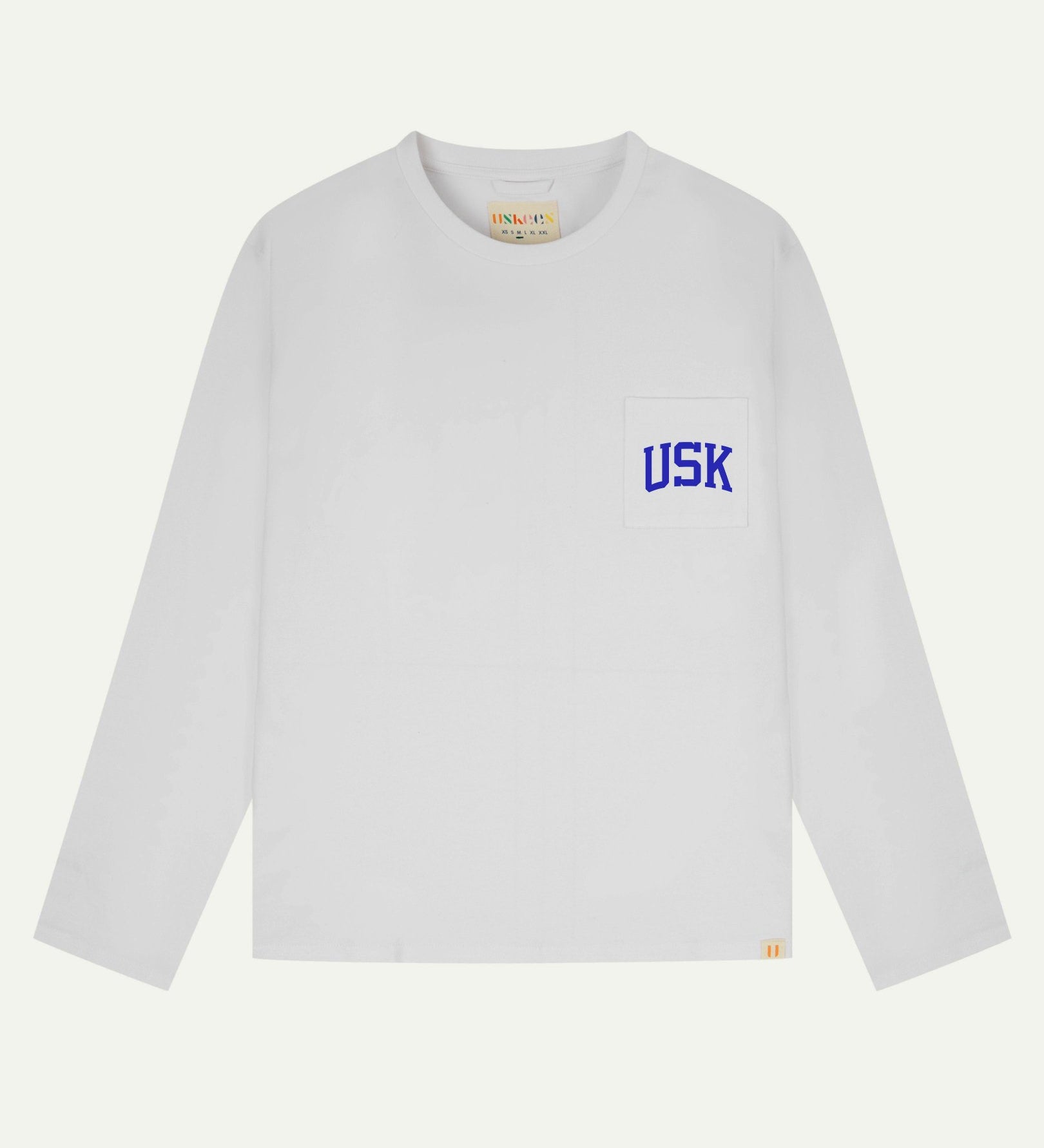 Full flat view of white organic cotton signature long sleeve T-shirt for men, showing the varsity inspired 'USK' logo in blue on the chest pocket, and the Uskees branding labels on the neck and hem.