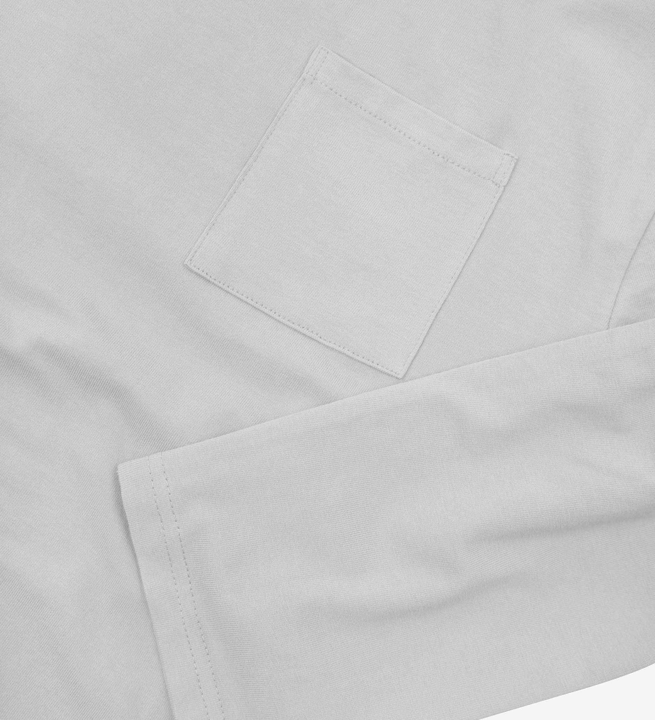 Closer look at the chest pocket and cuff of the white organic cotton long sleeve T-shirt showing texture of the medium weight organic cotton jersey.