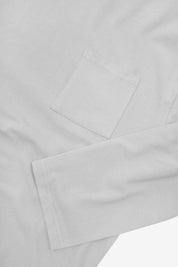 Closer look at the chest pocket and cuff of the white organic cotton long sleeve T-shirt showing texture of the medium weight organic cotton jersey.