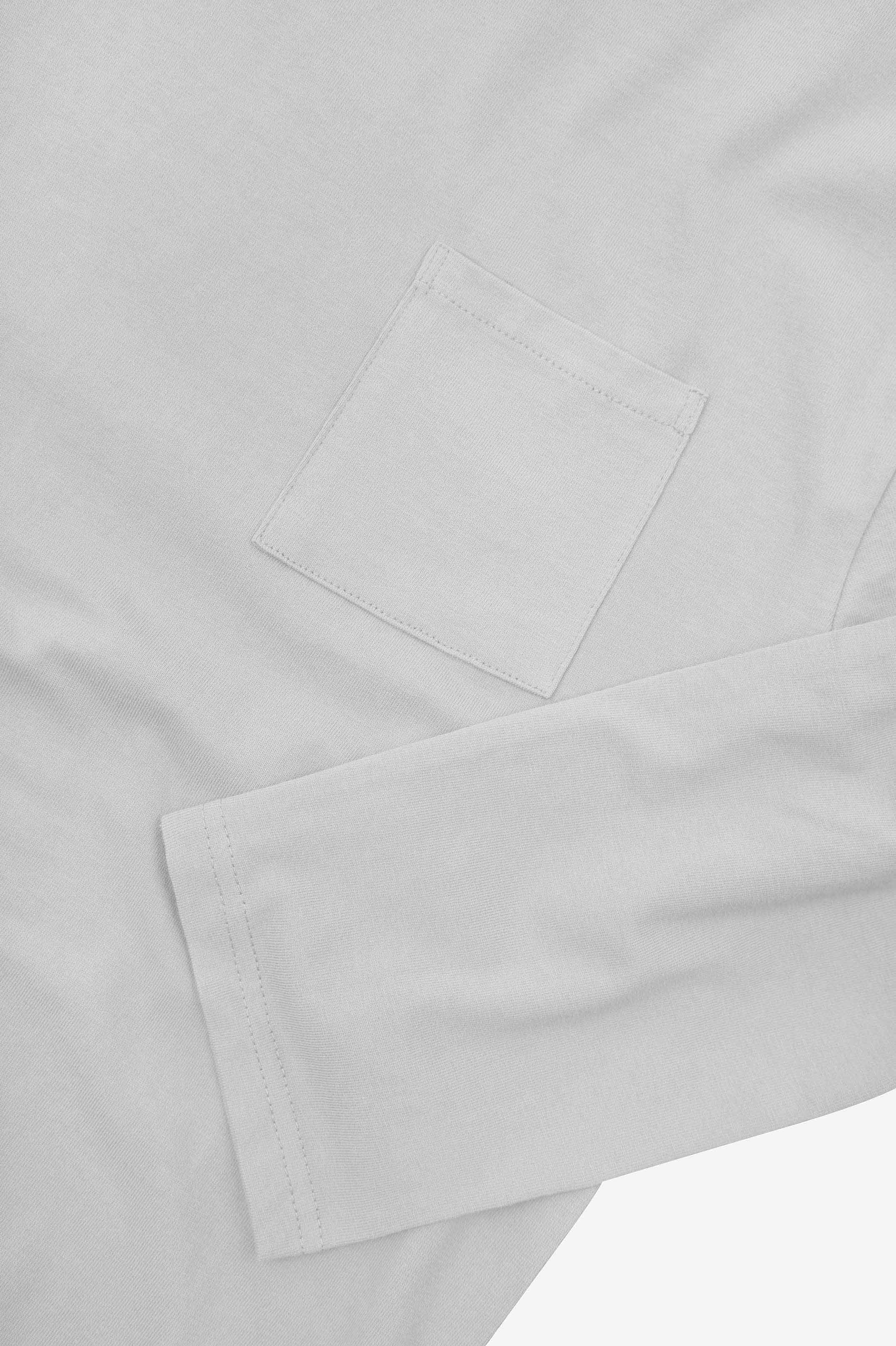 Closer look at the chest pocket and cuff of the white organic cotton long sleeve T-shirt showing texture of the medium weight organic cotton jersey.