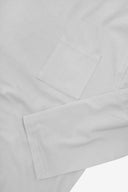 Closer look at the chest pocket and cuff of the white organic cotton long sleeve T-shirt showing texture of the medium weight organic cotton jersey.
