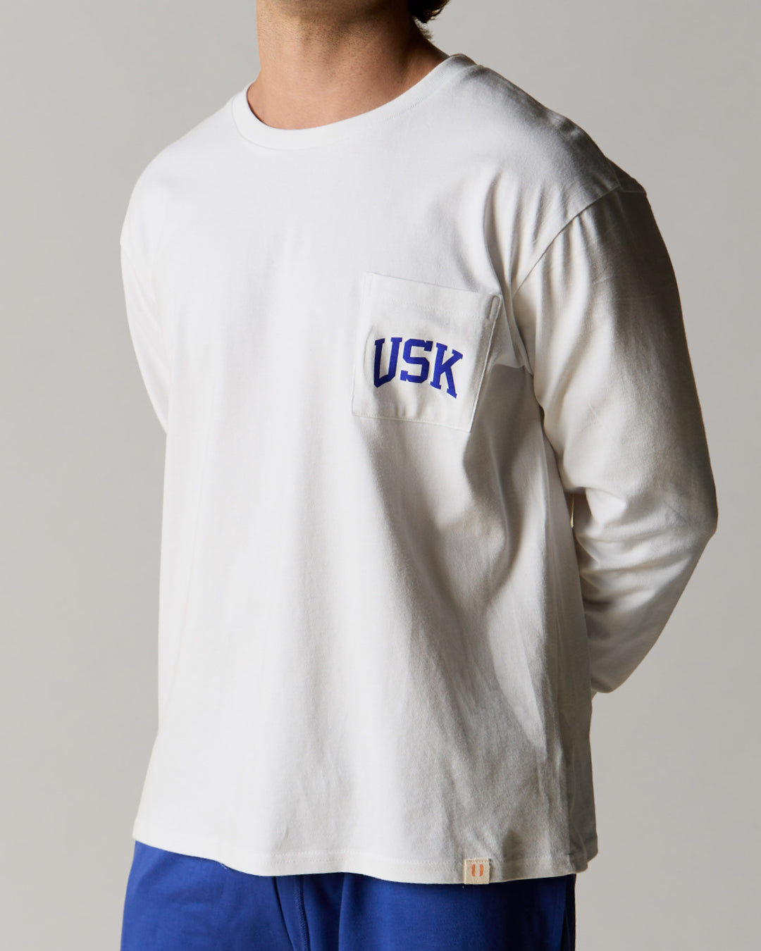 Front view wearing the white organic cotton signature long sleeve T-shirt for men, demonstrating the loose, relaxed fit.