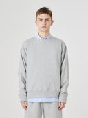 Front view close up male model shot of Uskees grey marl Champ Sweatshirt for men, paired with matching pants.