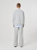 Back view male model shot of Uskees grey marl Champ Sweatshirt for men, demonstrating loose, oversized silhouette.
