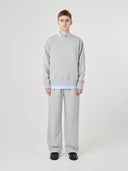 Male model wearing an Uskees gray marl Champ sweatshirt and matching Champ joggers.