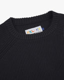 Front close up view of Uskees midnight blue sweater for men with focus on the ribbed knit, crew neck and brand label.