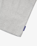 View of hemline of Uskees grey marl cotton vest with focus on breathable, non-see-through fabric and blue 'USKEES' logo tab.