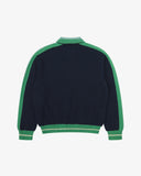 Back flat view of an Uskees navy blue zip front jacket with green accents, presented on a white background.