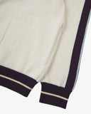 Close-up of a men's cream track jacket sleeve with purple trim on a light background