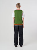 Back view of a male model wearing a green tank top over a white sleeveless shirt.