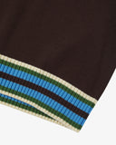 Close-up of an Uskees brown men's tank top with a striped hem featuring blue, green, and beige colors.
