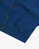 Close up view of Uskees admiral blue lambswool Harris cardigan with focus on the ribbed detailing on hem, cuffs and pockets.