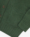 Close up view of Uskees moss-green lambswool Harris cardigan with focus on the ribbed detailing on hem, cuffs and pockets.