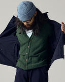 Model wearing moss-green lambswool Harris cardigan with overcoat.