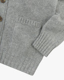 Close up view of Uskees stone-grey lambswool Harris cardigan with focus on the ribbed detailing on hem, cuffs and pockets.