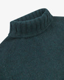 Close-up shot of an Uskees dark green turtleneck sweater for men showing the ribbed neck detail.