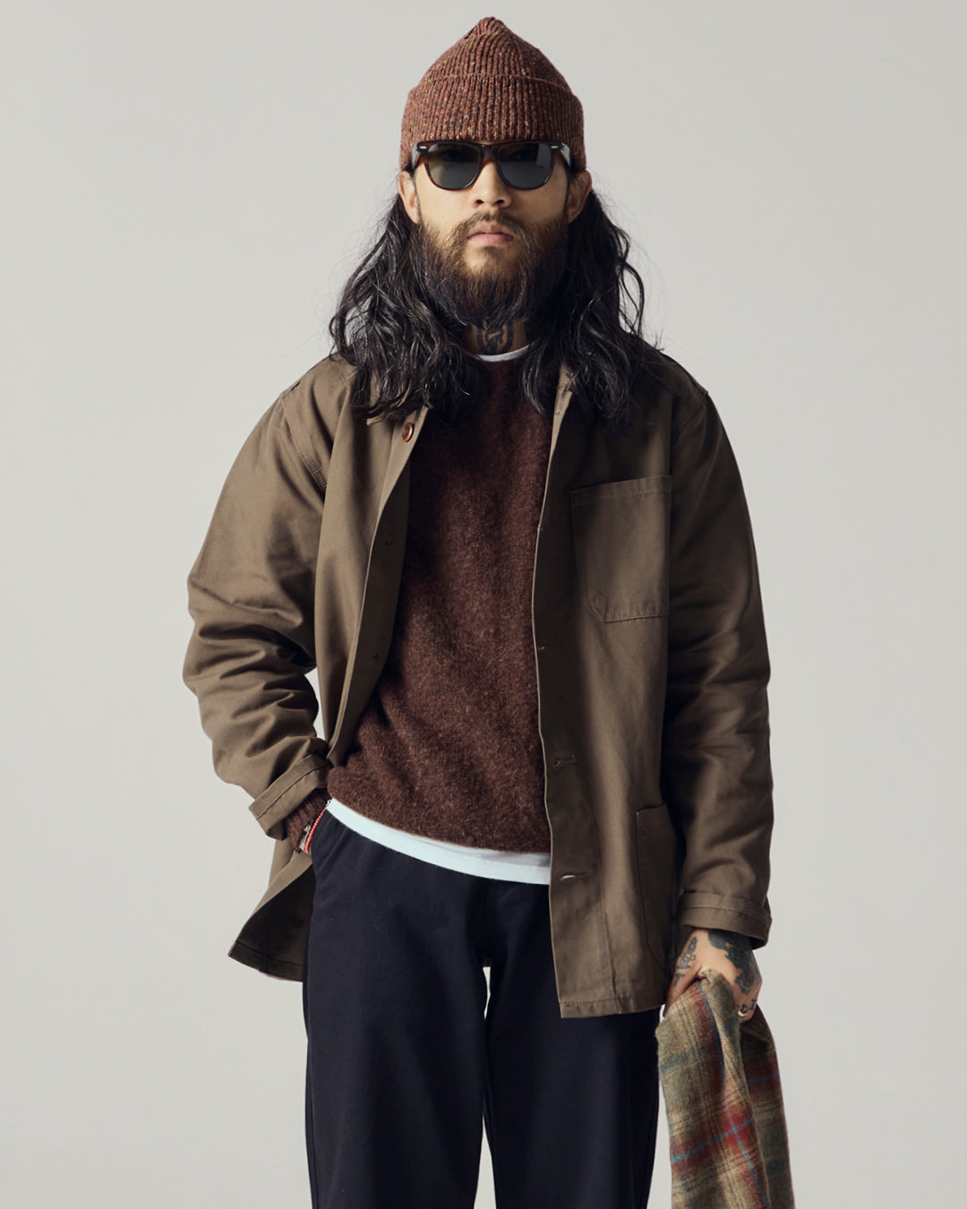 Male model wearing an Uskees brown shacket, loam brown sweater, and beanie with sunglasses.