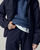 Model wearing Uskees 7021 Skye lambswool sweater in sapphire blue with focus on waist area.