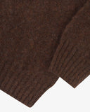 Close up shot of Uskees loam brown men's sweater showing the ribbed hem and ribbed cuff detail.