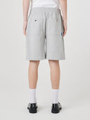 Back view of model wearing Uskees 7022 gray marl shorts with a white t-shirt. View of 2 back pockets and logo tab.