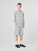 Full-length view of male model wearing Uskees 7022 gray marl shorts with a matching 7011 Champ sweatshirt.