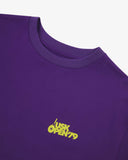Neckline close-up of purple organic cotton T-shirt, with focus on the neck tape reinforcement and yellow brand graphics