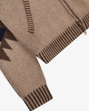 Close-up of an Uskees knit cardigan for men in beige with dark brown striped ribbed cuffs and hem, plus a partial geometric pattern on the sleeve.