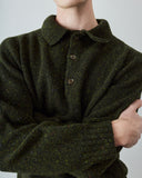A close-up of a male model wearing a dark olive green knit polo sweater with subtle multicolor flecks, featuring a collar and three buttons.