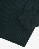 Close up of an Uskees dark blue men's sweater showing the cuff, sleeve and ribbed welt detail.