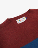 Close up view of Uskees red and blue striped sweater for men showing the brand label at neck.