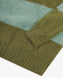 Close-up of a green and pale blue striped Uskees men's sweater on a white background.