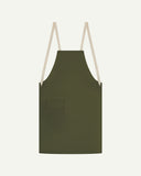 Flat shot of Uskees green canvas apron showing cream straps and front flap pocket.