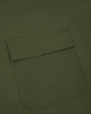 Close up shot of Uskees green canvas apron showing front flap pocket.