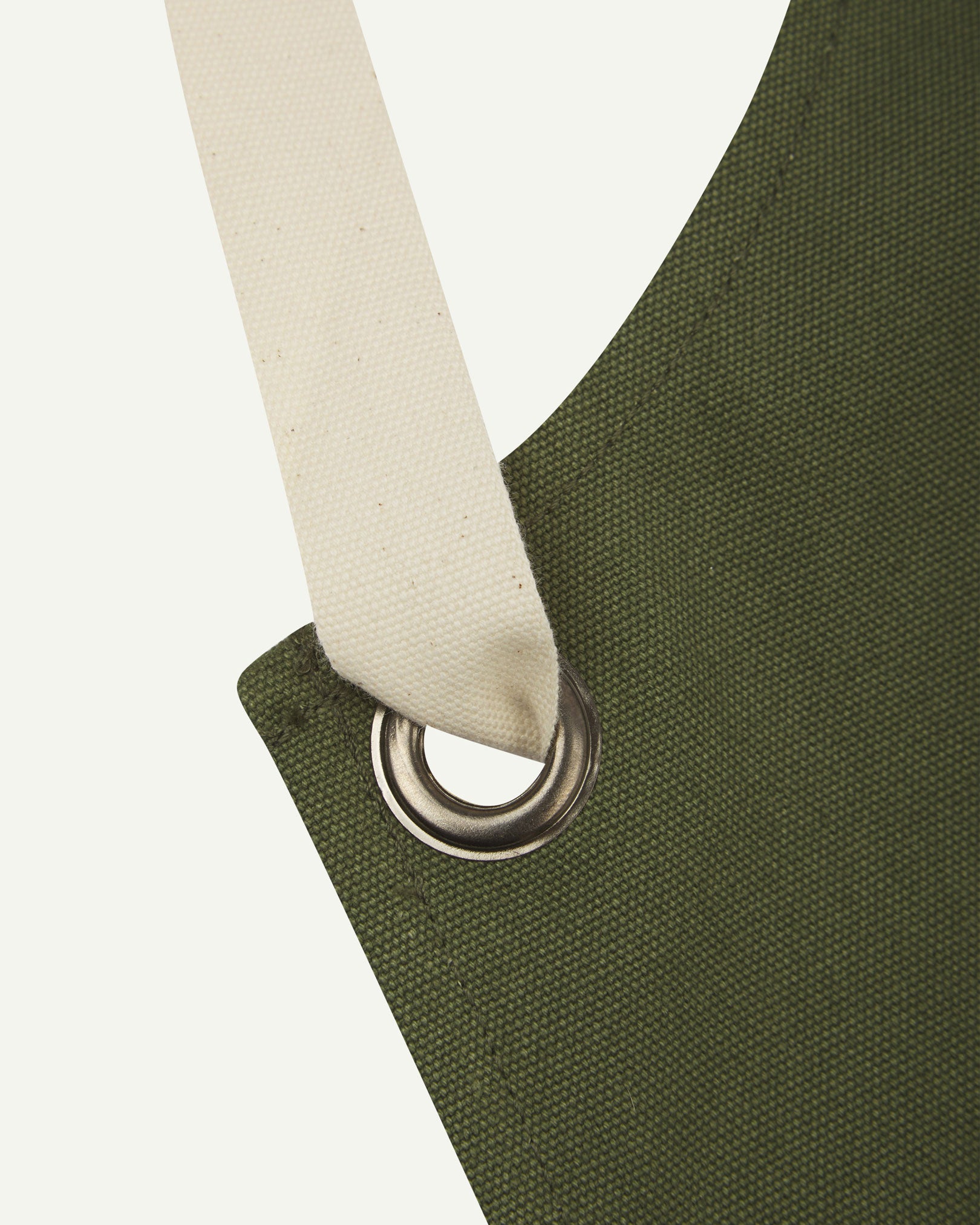 Close up shot of Uskees unisex green canvas apron showing cream strap.