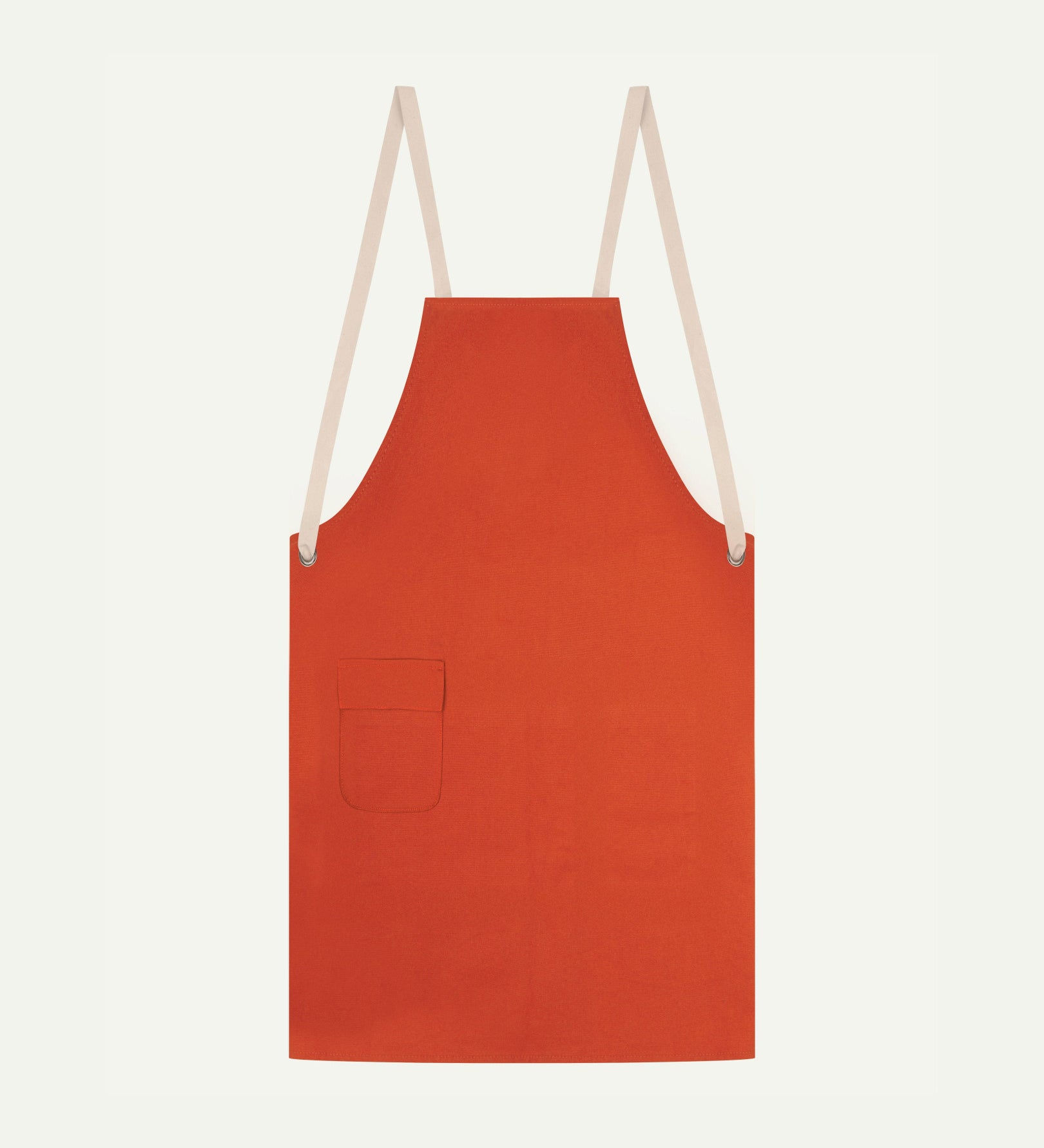 Flat shot of Uskees gold-orange canvas apron showing cream straps and front pocket.