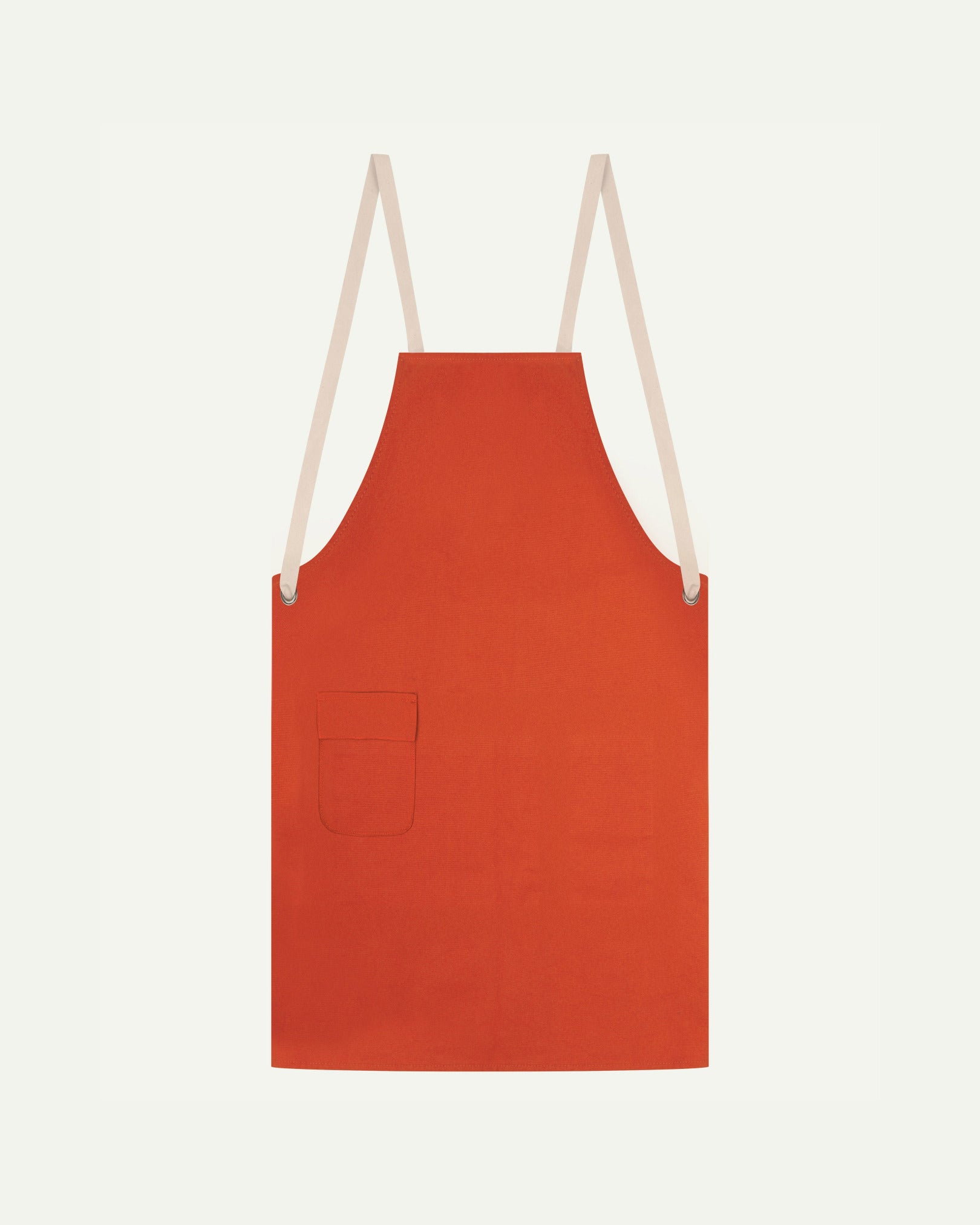 Flat shot of Uskees gold-orange canvas apron showing cream straps and front pocket.