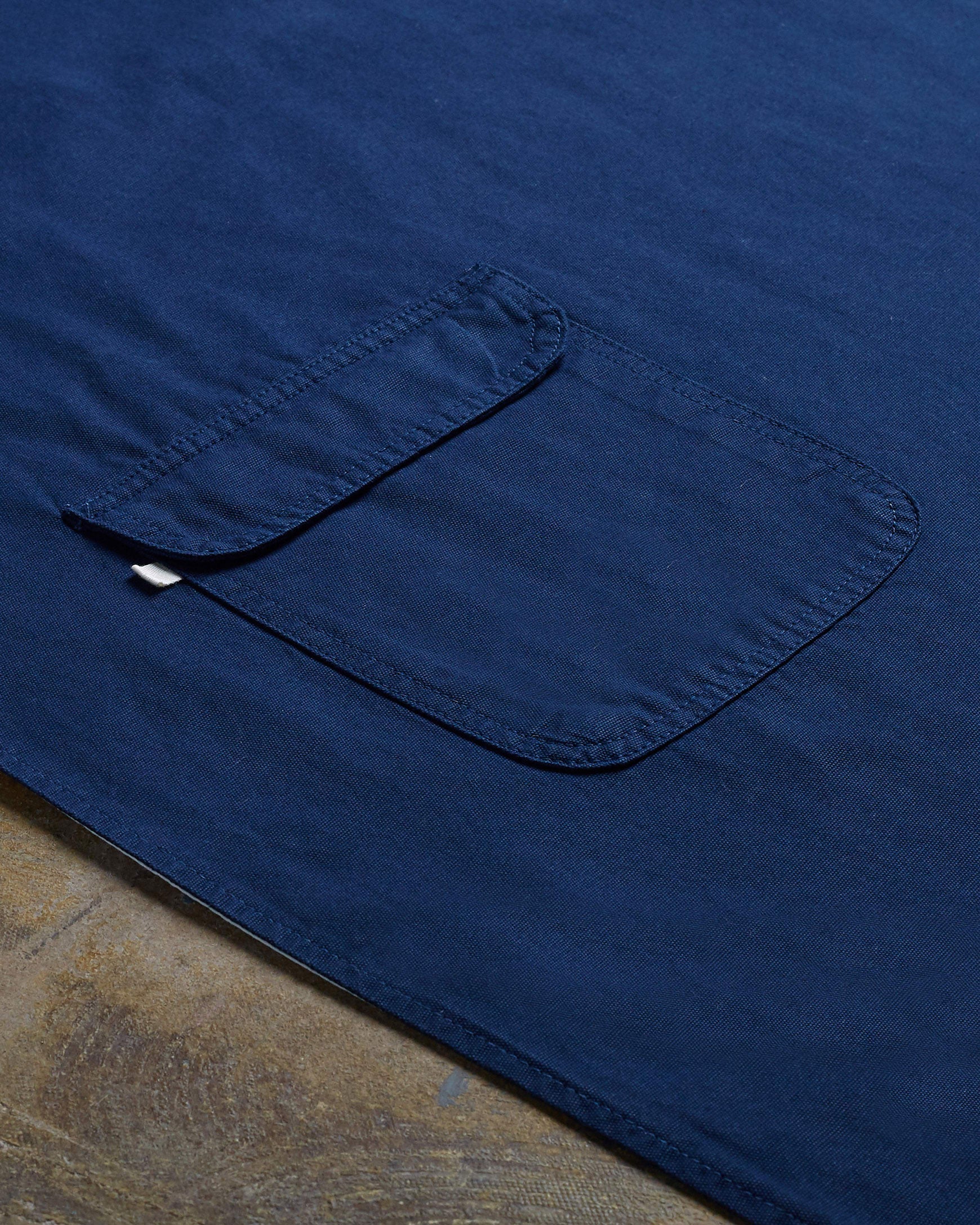 Angled flat view of navy-blue #9001 work apron by Uskees. Showing hip pocket and clearer view of organic cotton fabric texture.