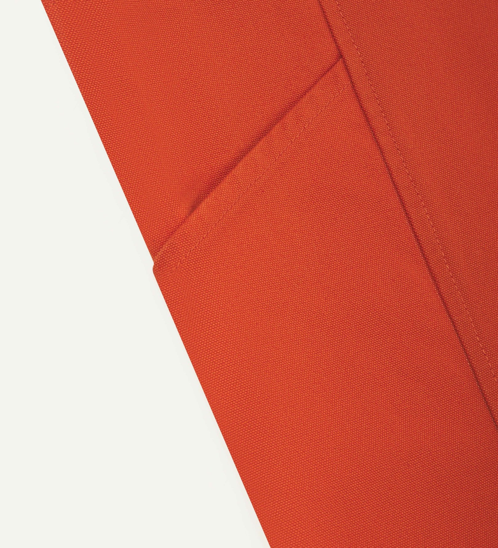 Close-up view of the Uskees Japanese-style 9003 gold-orange canvas apron with focus on one of 2 side pockets.