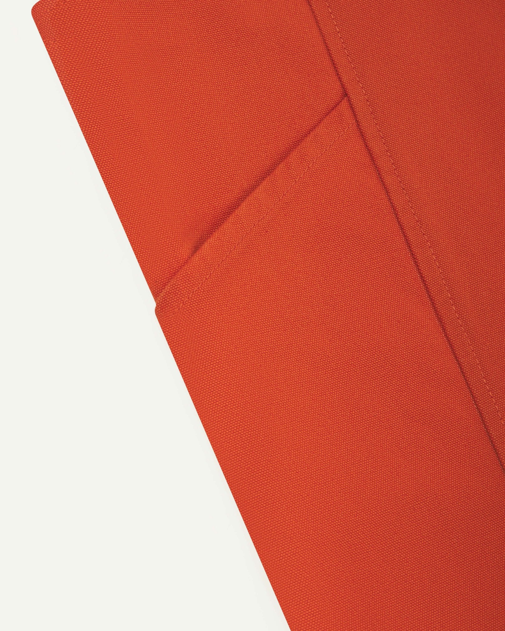 Close-up view of the Uskees Japanese-style 9003 gold-orange canvas apron with focus on one of 2 side pockets.