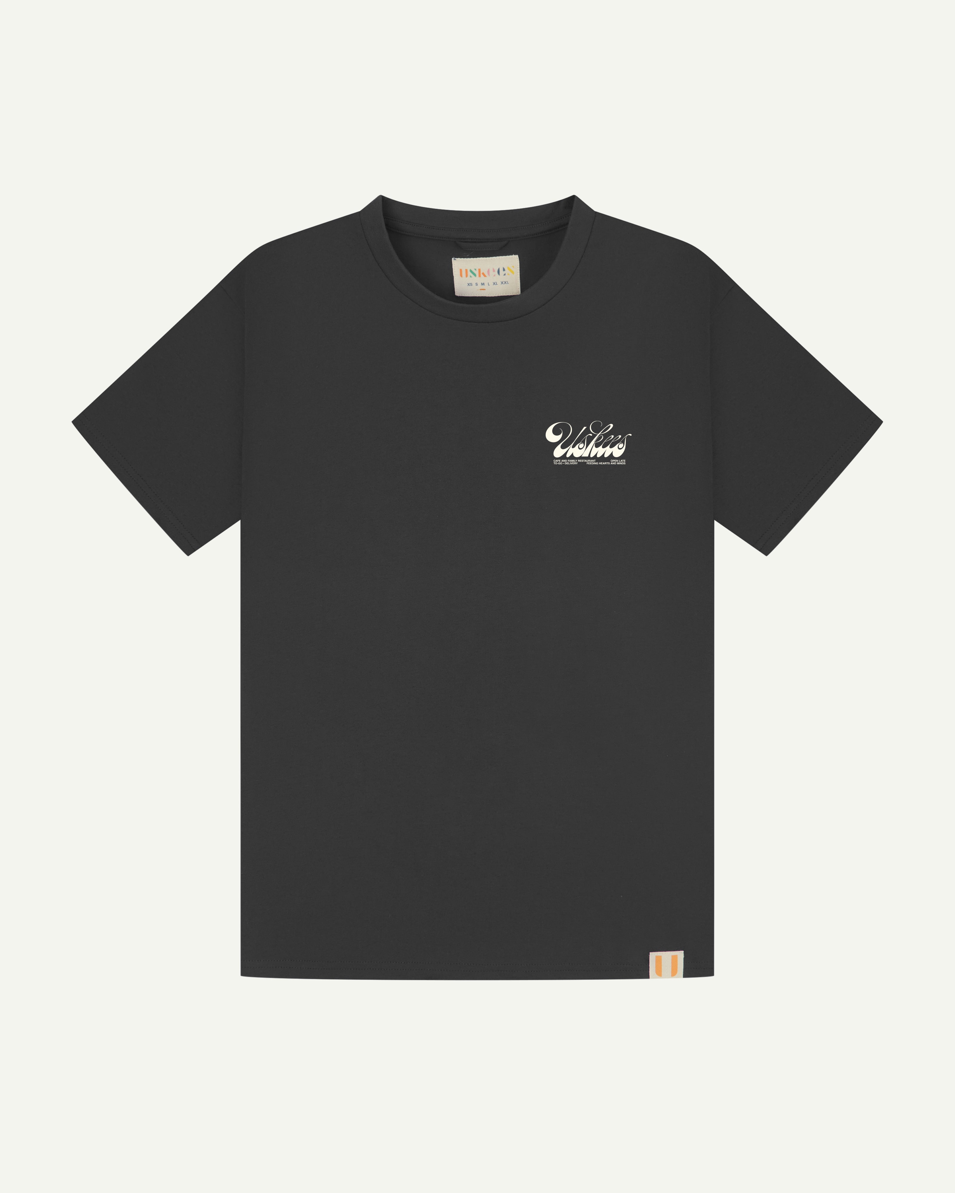 front flat shot of uskees men's graphic Tee in faded black showing the 'diner' logo in cream